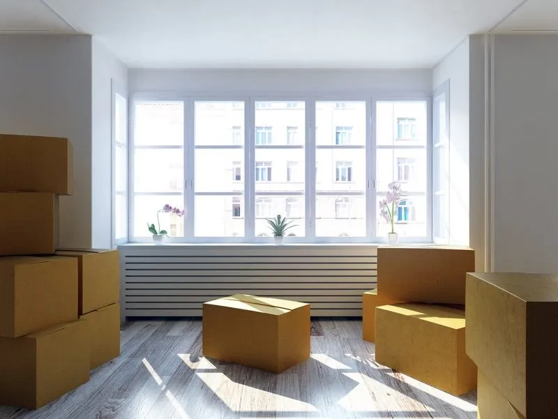 A bright empty room with moving boxes, ready for an end of tenancy clean